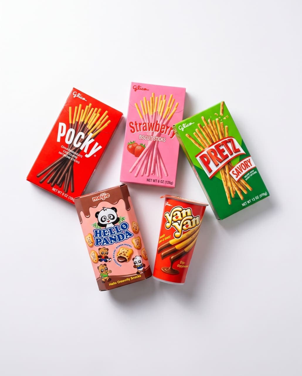 Biscuit snacks: chocolate and strawberry Pocky, savory Pretz, Hello Panda, and a Yan Yan dip cup on a white studio background